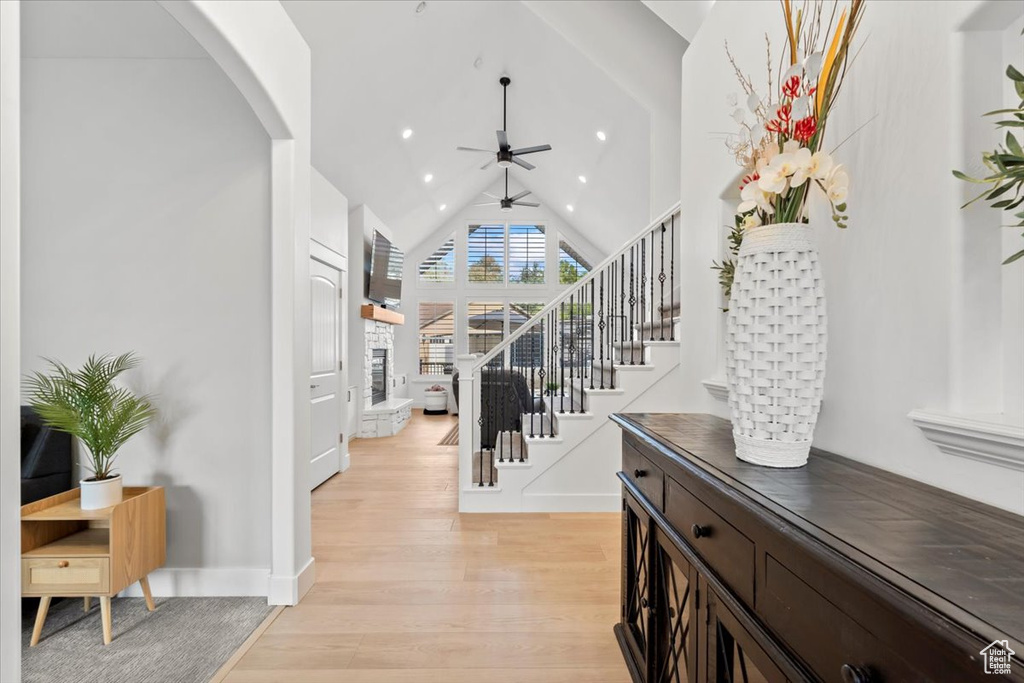 Entrance foyer featuring a ceiling fan, arched walkways, light wood-type flooring, stairs, and recessed lighting