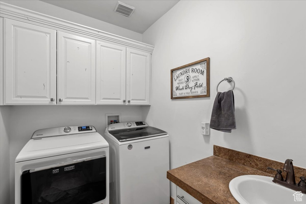 Washroom with washing machine and clothes dryer and cabinet space