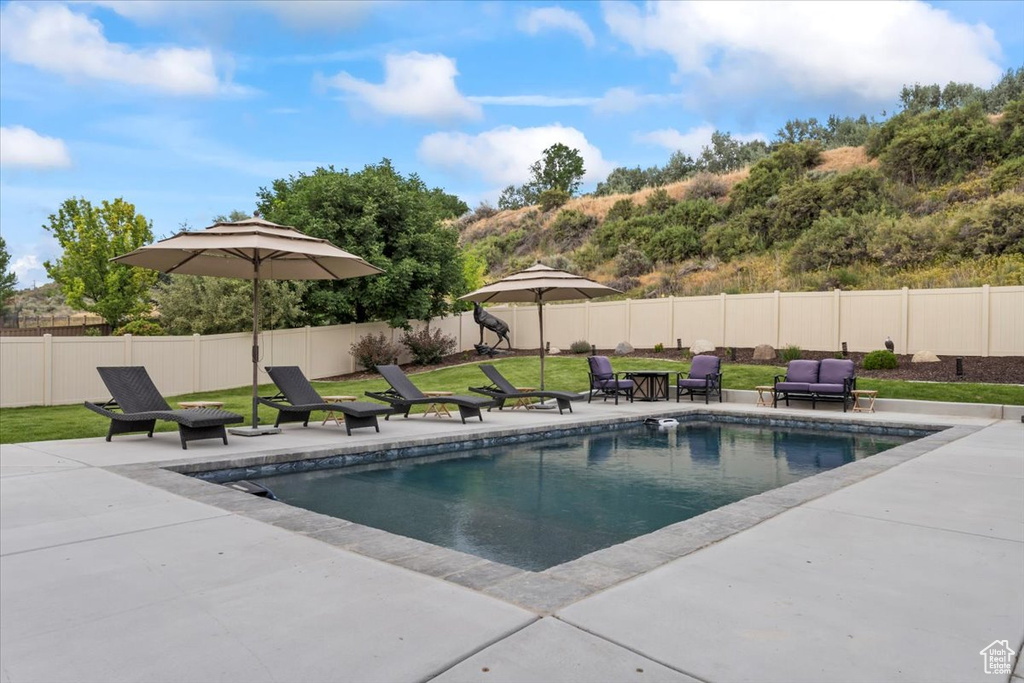View of swimming pool with a patio area and a fenced backyard