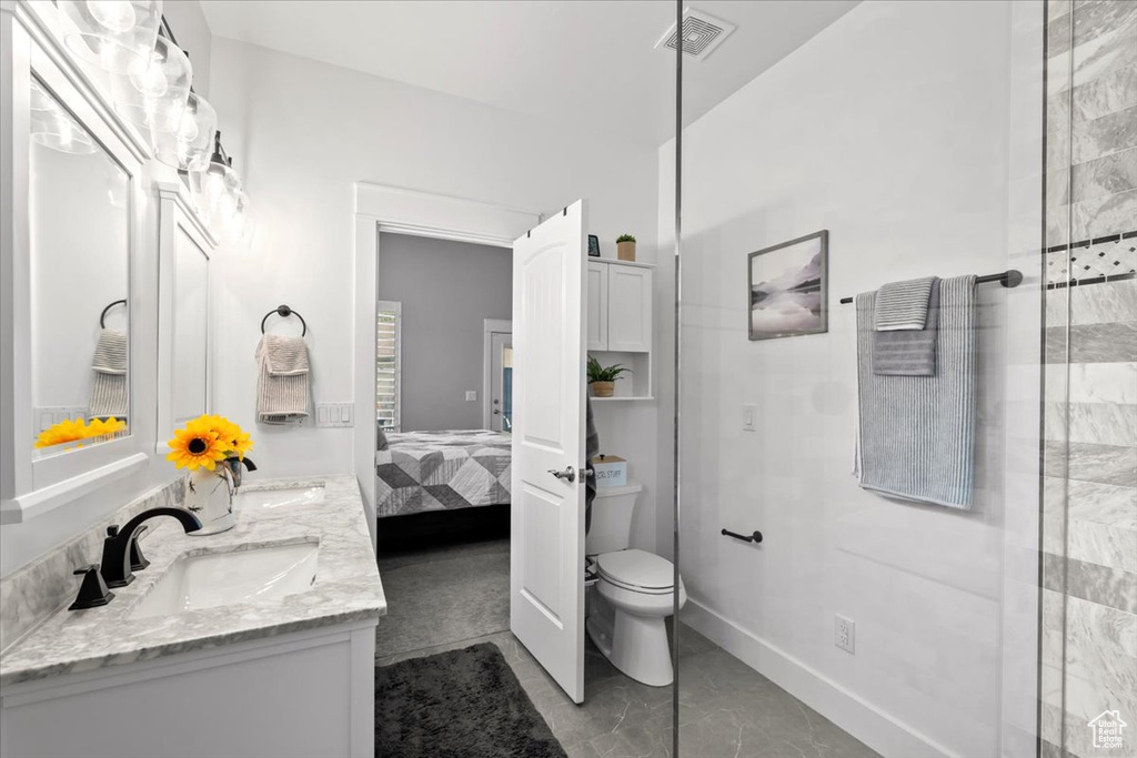 Ensuite bathroom featuring double vanity and toilet