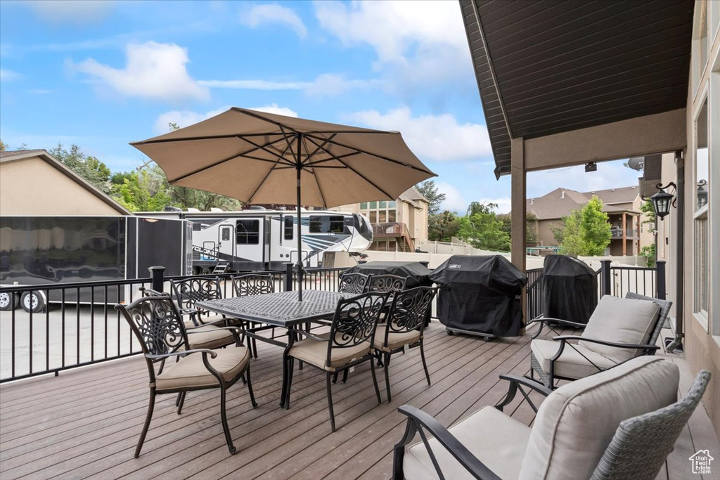 Wooden terrace featuring outdoor dining area and area for grilling
