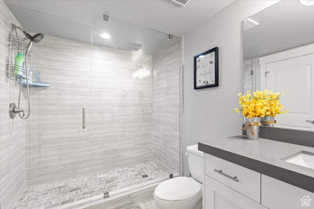 Full bathroom with vanity, a stall shower, and recessed lighting