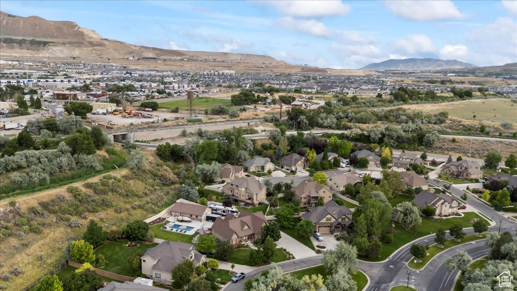 Aerial view of property and surrounding area featuring a mountainous background and nearby suburban area