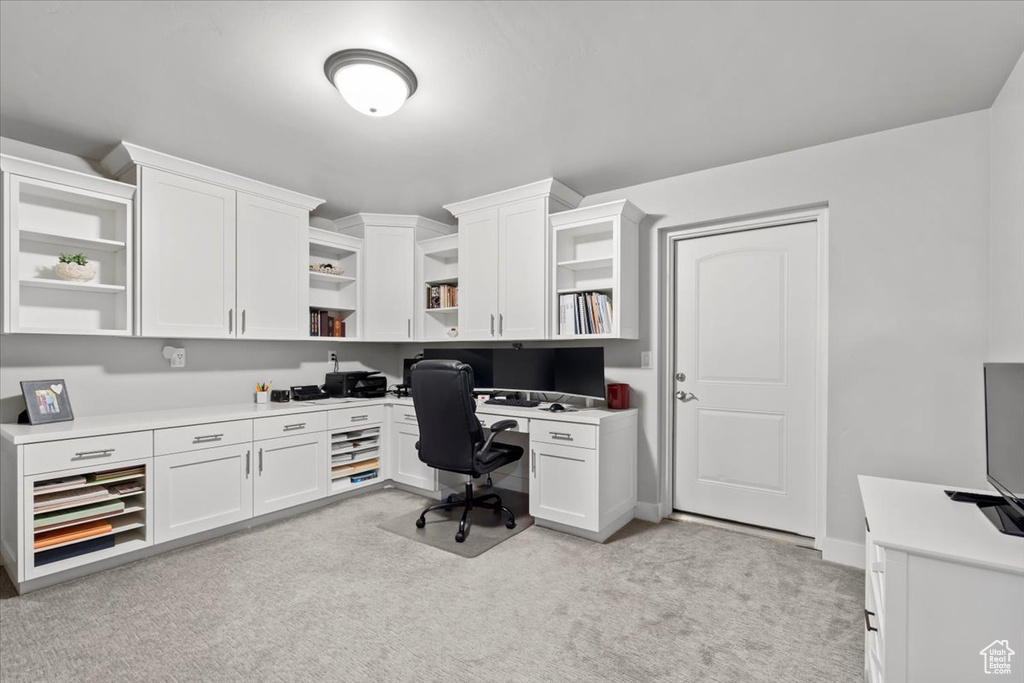 Office with light colored carpet and built in study area