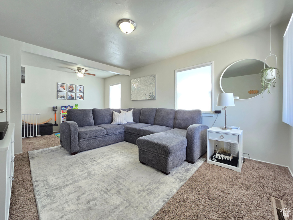 Carpeted living area with ceiling fan