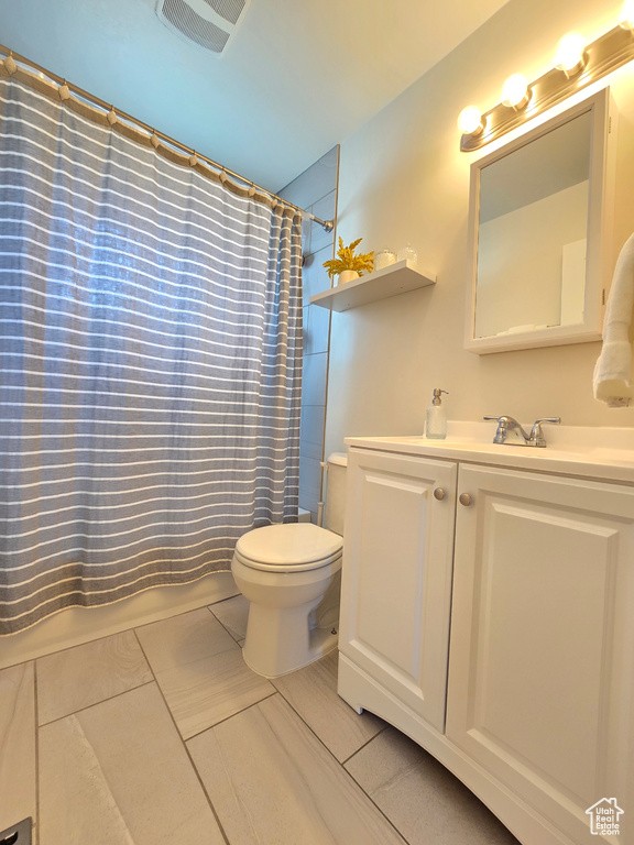 Bathroom featuring vanity, shower / bath combination with curtain, and tile patterned floors