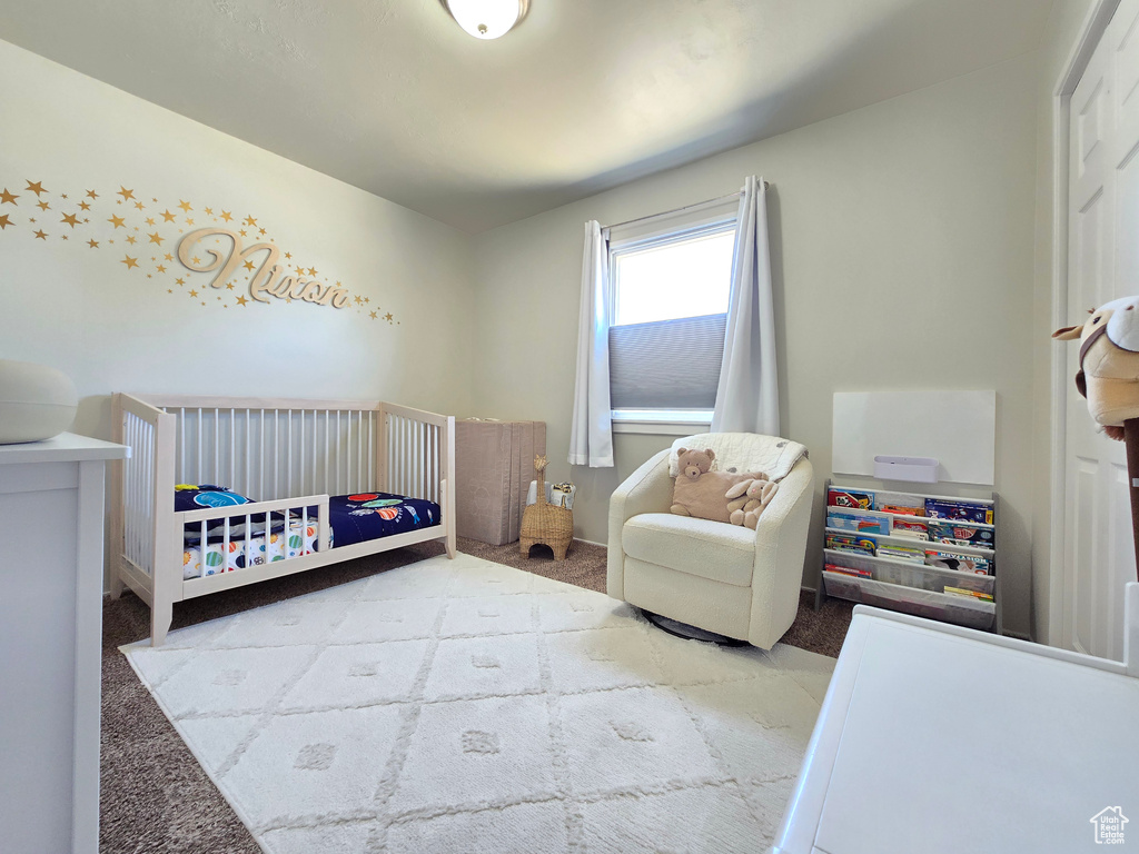 Carpeted bedroom with a crib