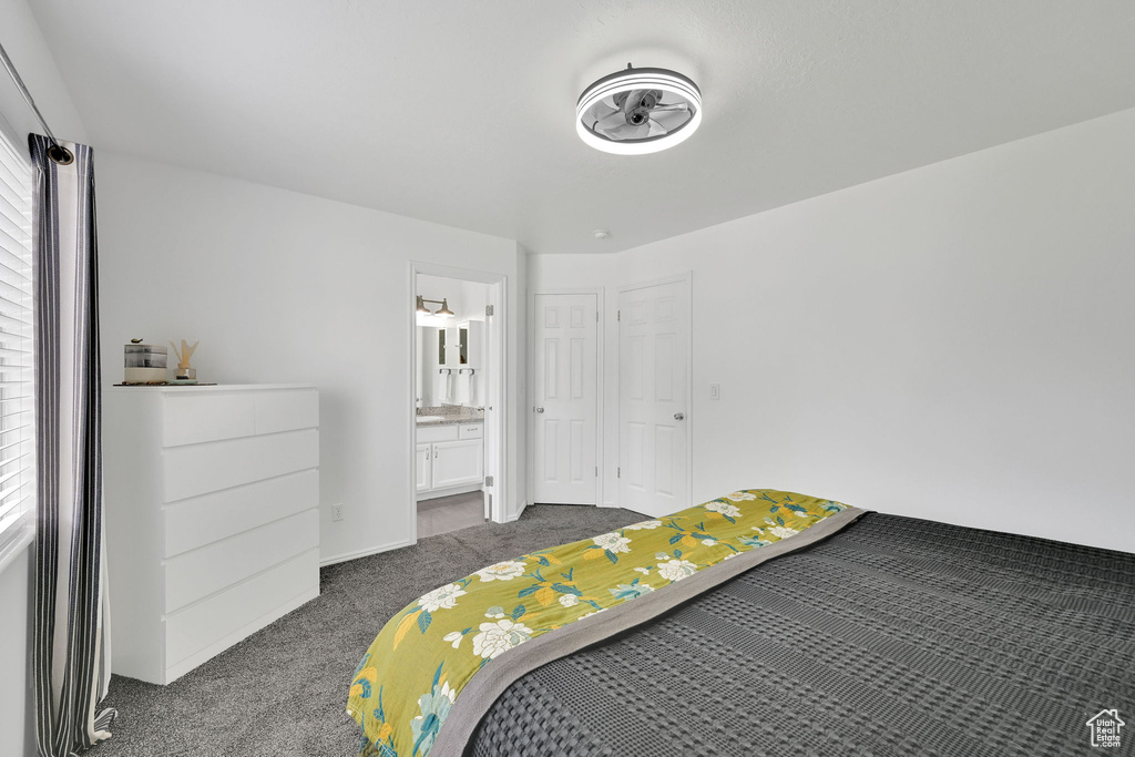 Bedroom with dark colored carpet and ensuite bath