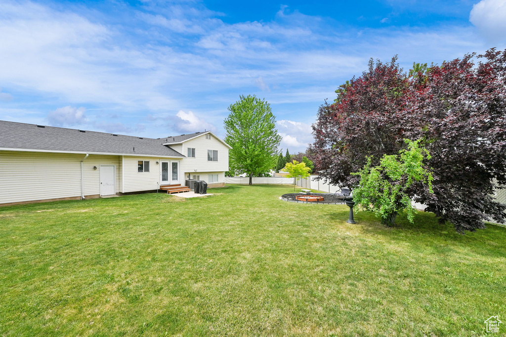 View of yard featuring an outdoor fire pit, french doors, and entry steps