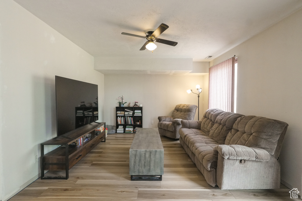 Living room featuring ceiling fan and light wood finished floors