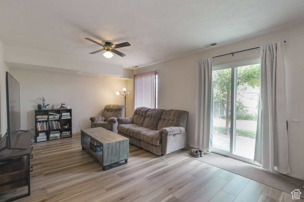 Living area with ceiling fan and light wood-type flooring