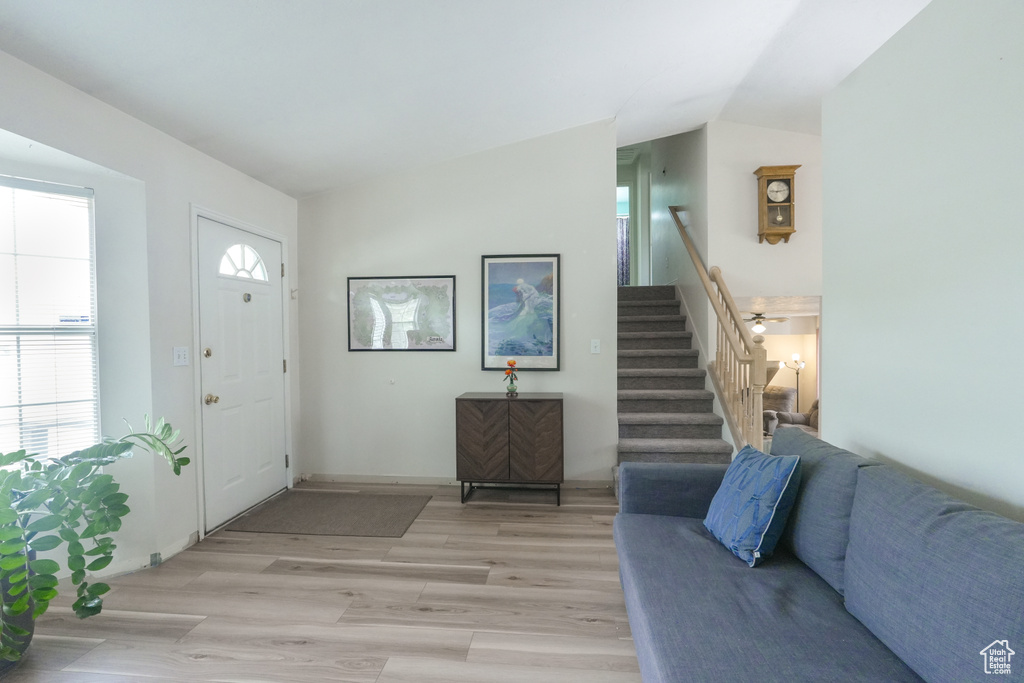 Entrance foyer featuring stairs, light wood-style flooring, and lofted ceiling