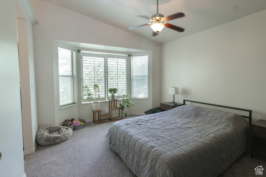Carpeted bedroom with vaulted ceiling and ceiling fan