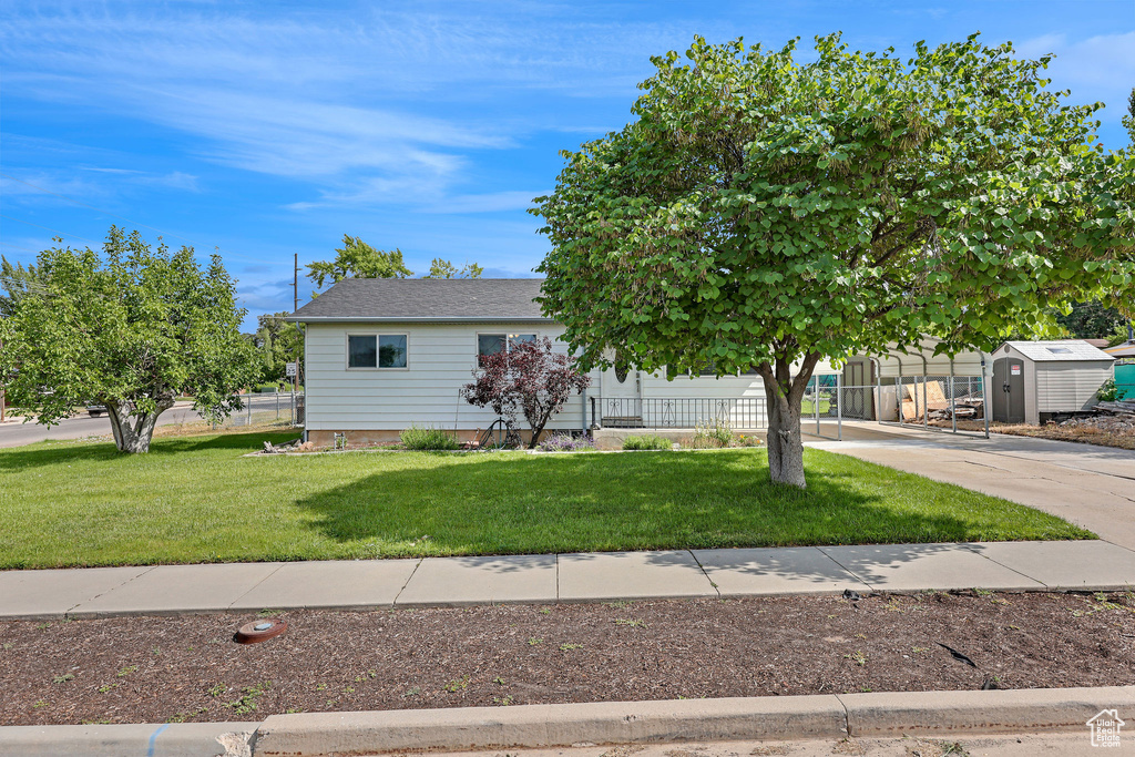 View of front of property featuring a storage shed and driveway