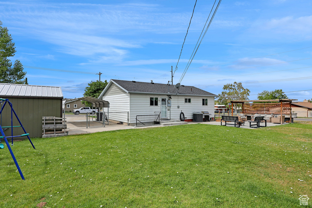 Rear view of house featuring a carport and a patio