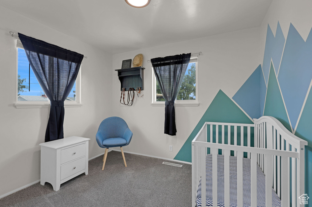 Bedroom featuring carpet floors and a crib