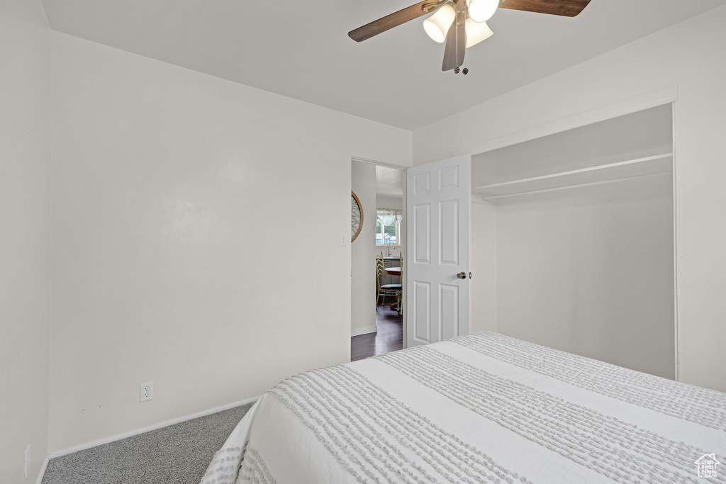 Carpeted bedroom featuring baseboards and a ceiling fan