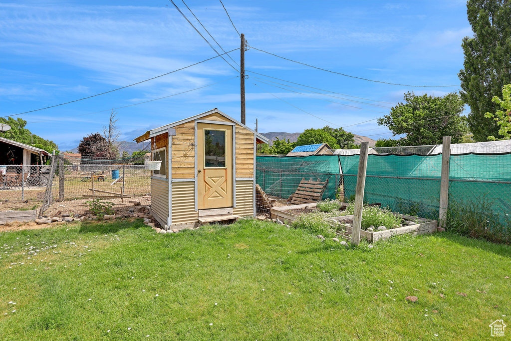 View of shed featuring a fenced backyard and a vegetable garden