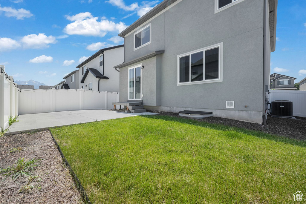 Back of property with entry steps, a fenced backyard, a patio, and stucco siding