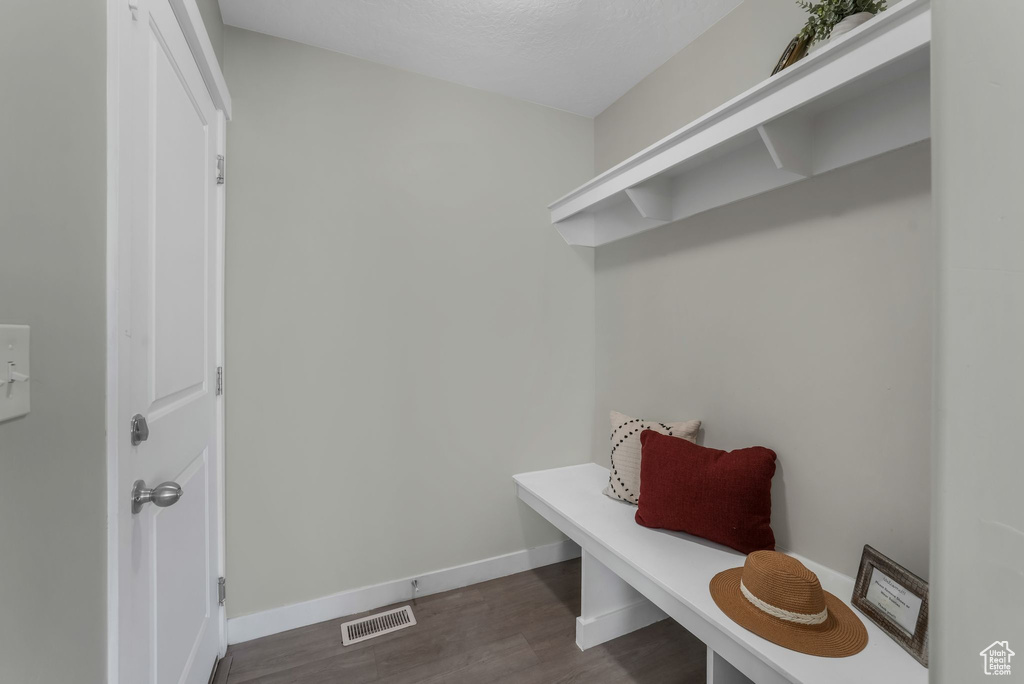 Mudroom featuring dark wood-style floors and baseboards