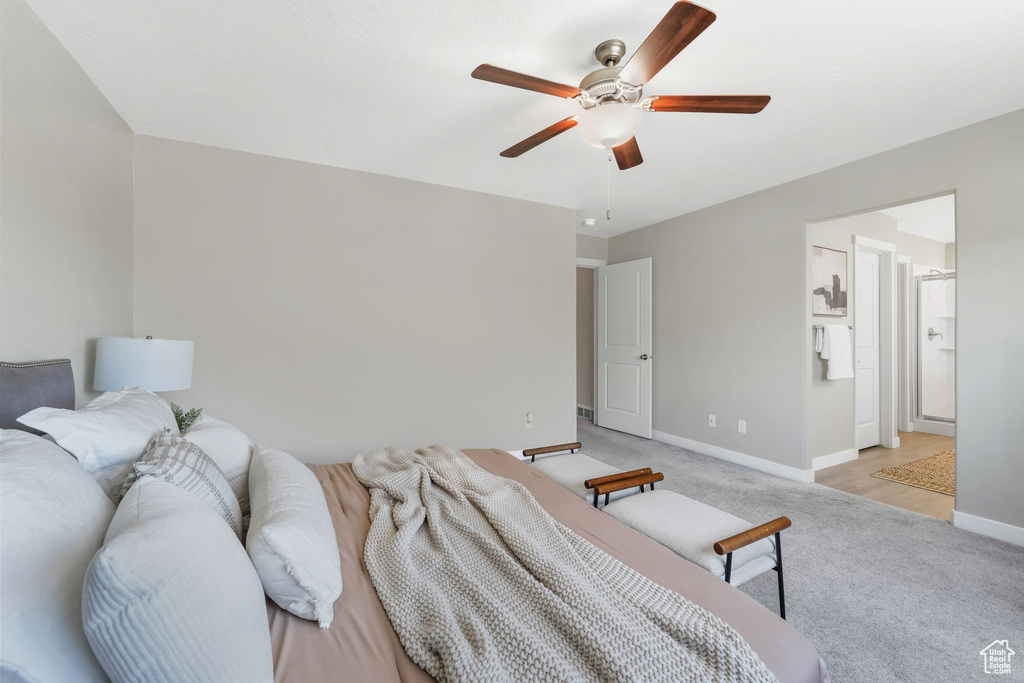 Bedroom with light colored carpet and a ceiling fan
