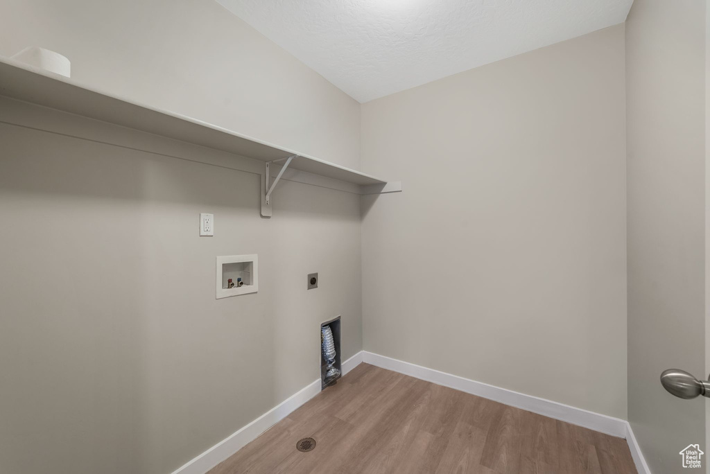 Laundry room with washer hookup, light wood-type flooring, and electric dryer hookup