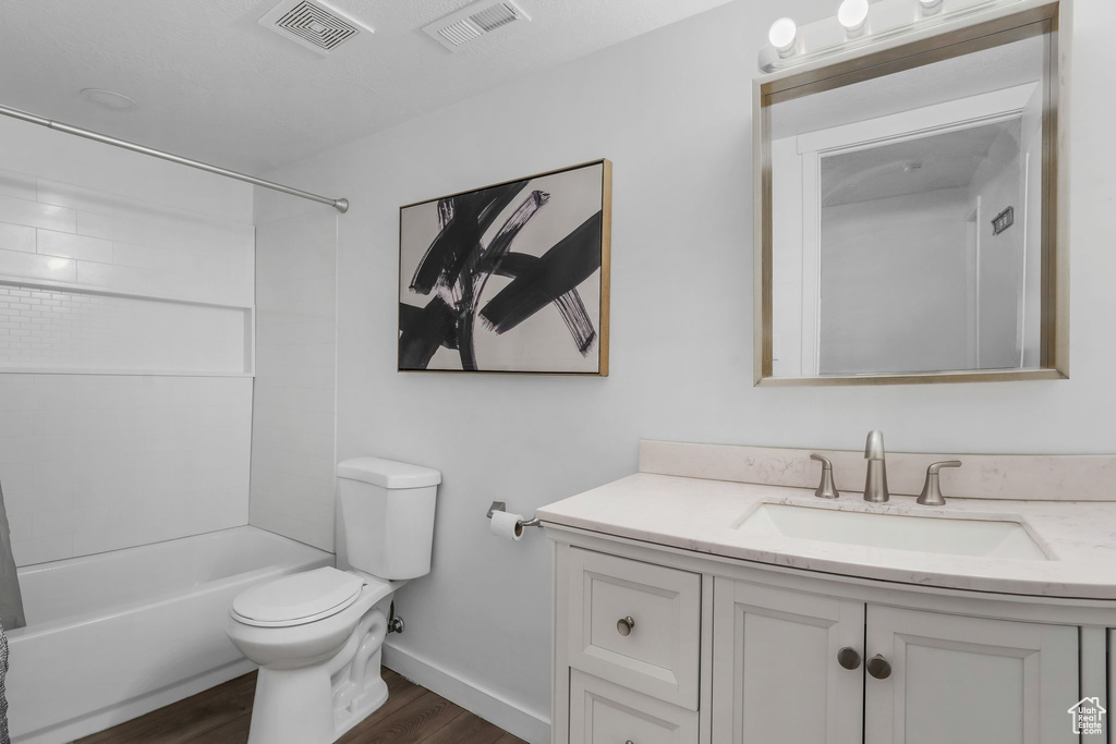 Bathroom with wood finished floors, vanity, and  shower combination