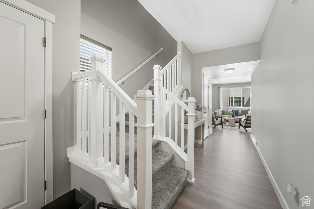 Staircase with wood finished floors and baseboards
