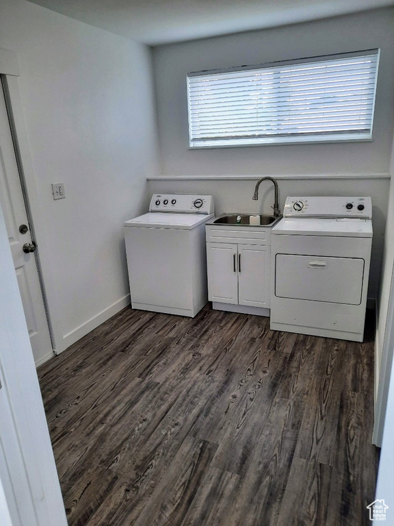 Laundry area with washing machine and dryer, dark wood finished floors, and cabinet space