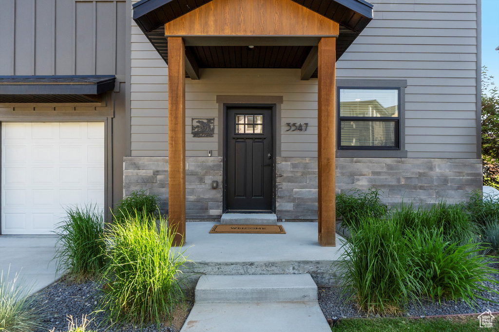 Entrance to property with stone siding and board and batten siding