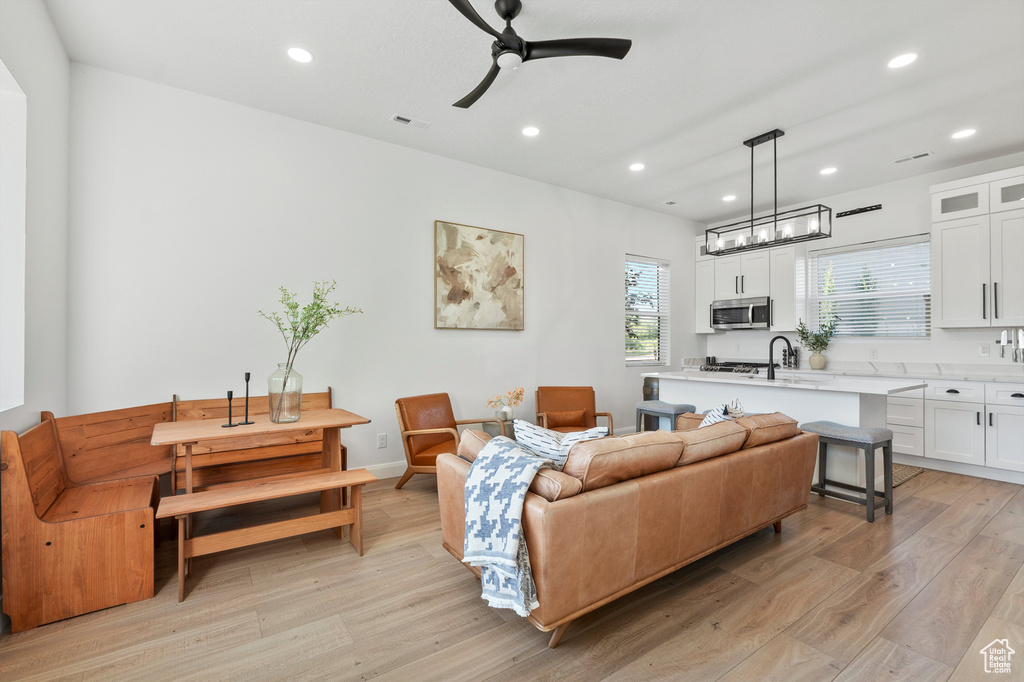 Living room featuring light wood-style flooring, recessed lighting, and a ceiling fan