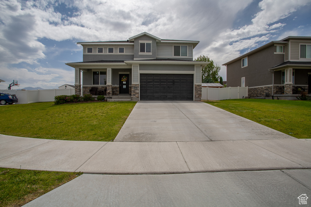 View of front of house featuring a porch, stone siding, concrete driveway, and a garage