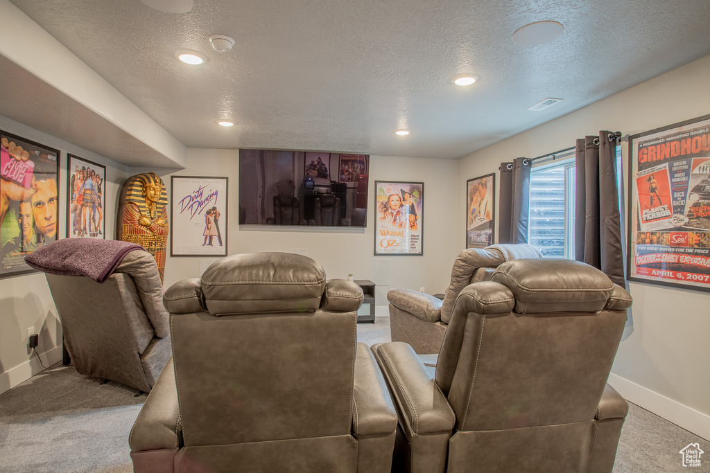 Carpeted home theater featuring a textured ceiling and recessed lighting