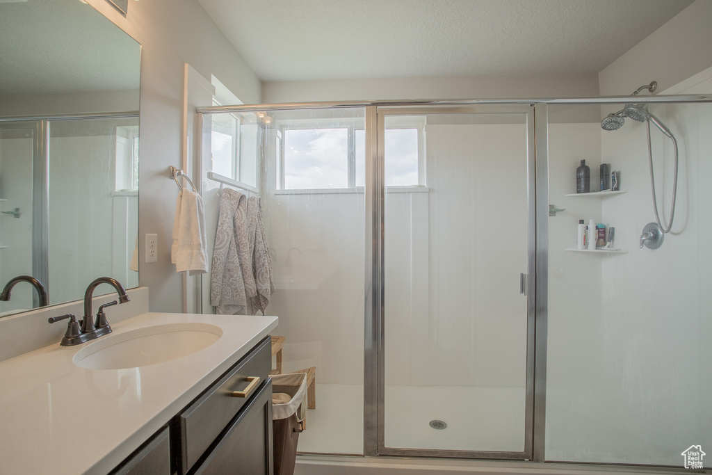Full bathroom featuring vanity and a shower stall