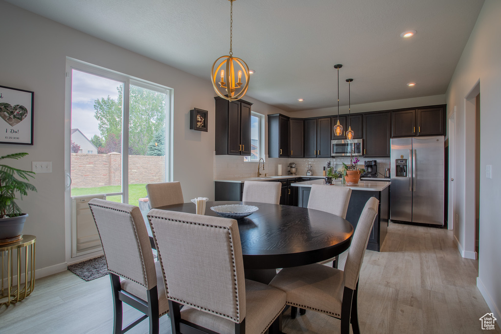 Dining room featuring a chandelier, light wood-style floors, and recessed lighting