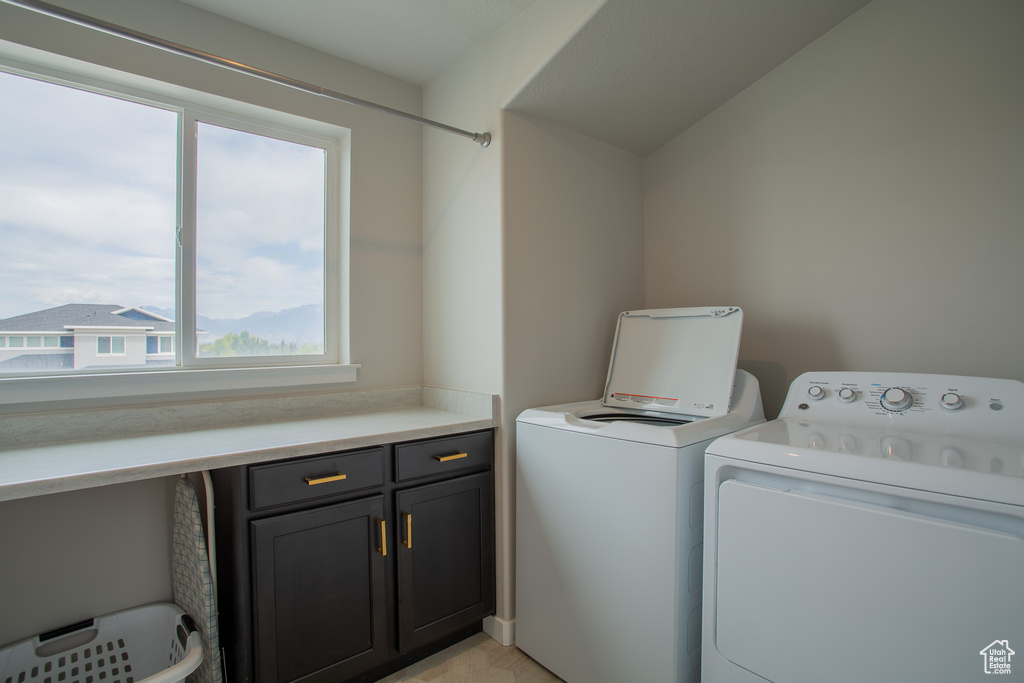 Washroom featuring washing machine and clothes dryer and cabinet space