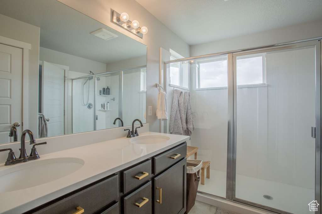 Full bath with a shower stall and double vanity
