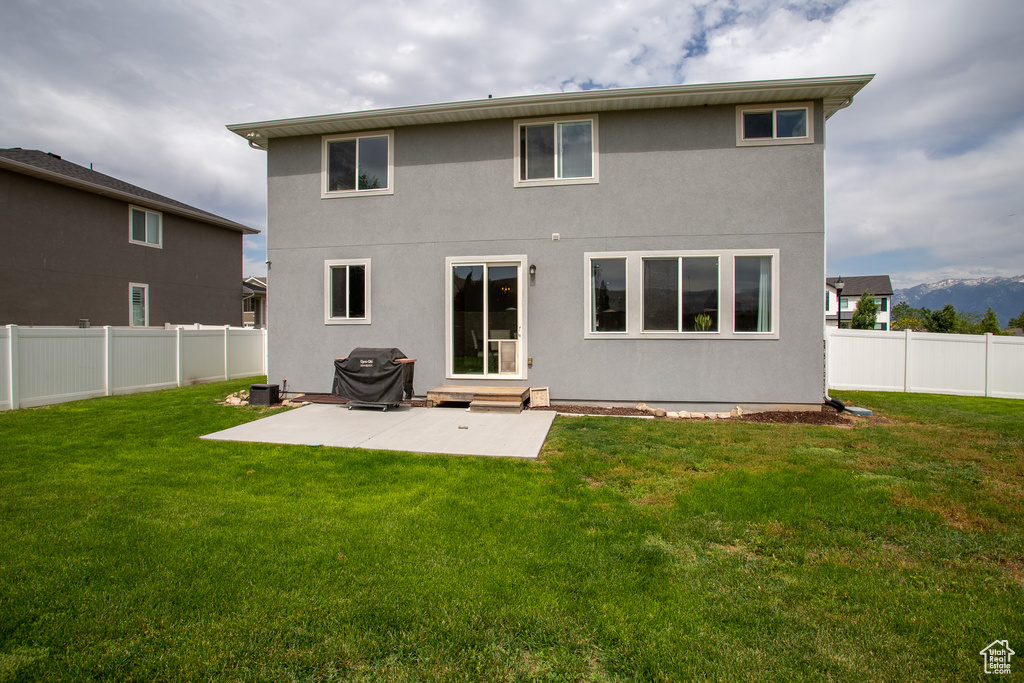 Back of house featuring a fenced backyard, a patio area, entry steps, and stucco siding