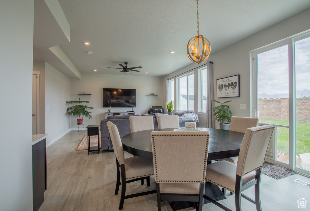 Dining space featuring healthy amount of natural light, a chandelier, light wood-style flooring, and recessed lighting