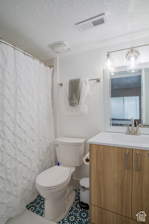 Full bathroom with vanity, a textured ceiling, and a shower with shower curtain