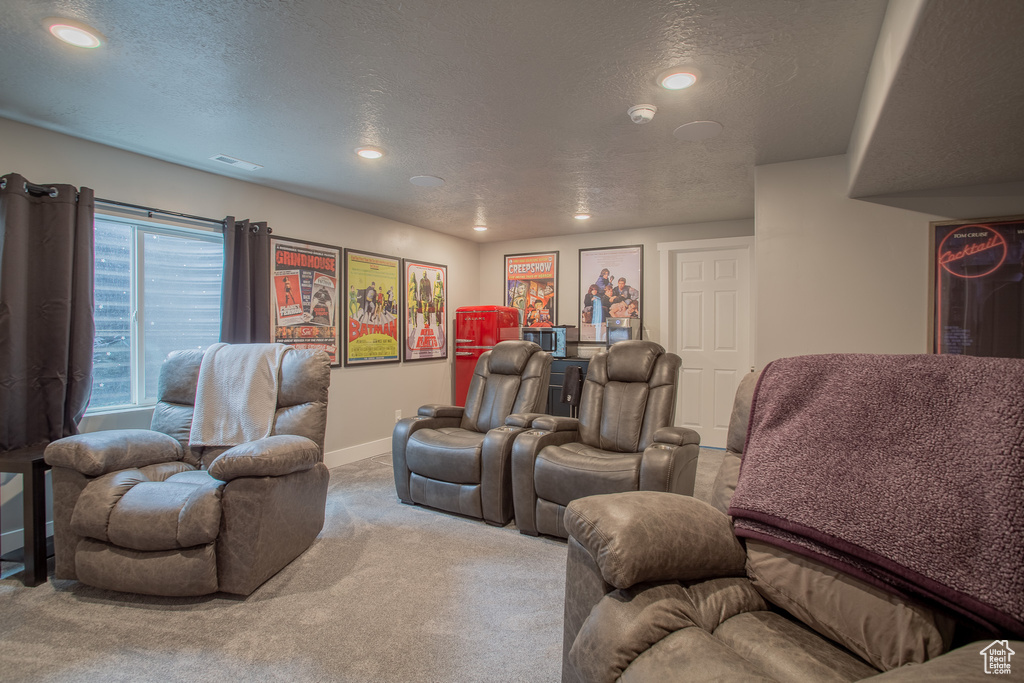 Carpeted home theater with recessed lighting and a textured ceiling