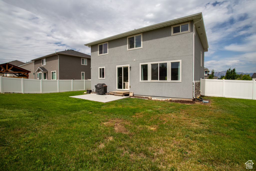 Back of property with a patio, stucco siding, a fenced backyard, and entry steps