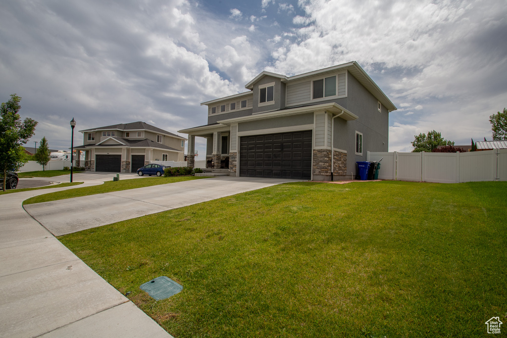 View of front of house with stone siding, a garage, and driveway