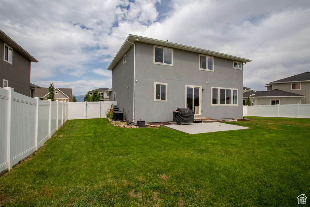 Rear view of house with a patio area, a fenced backyard, and stucco siding