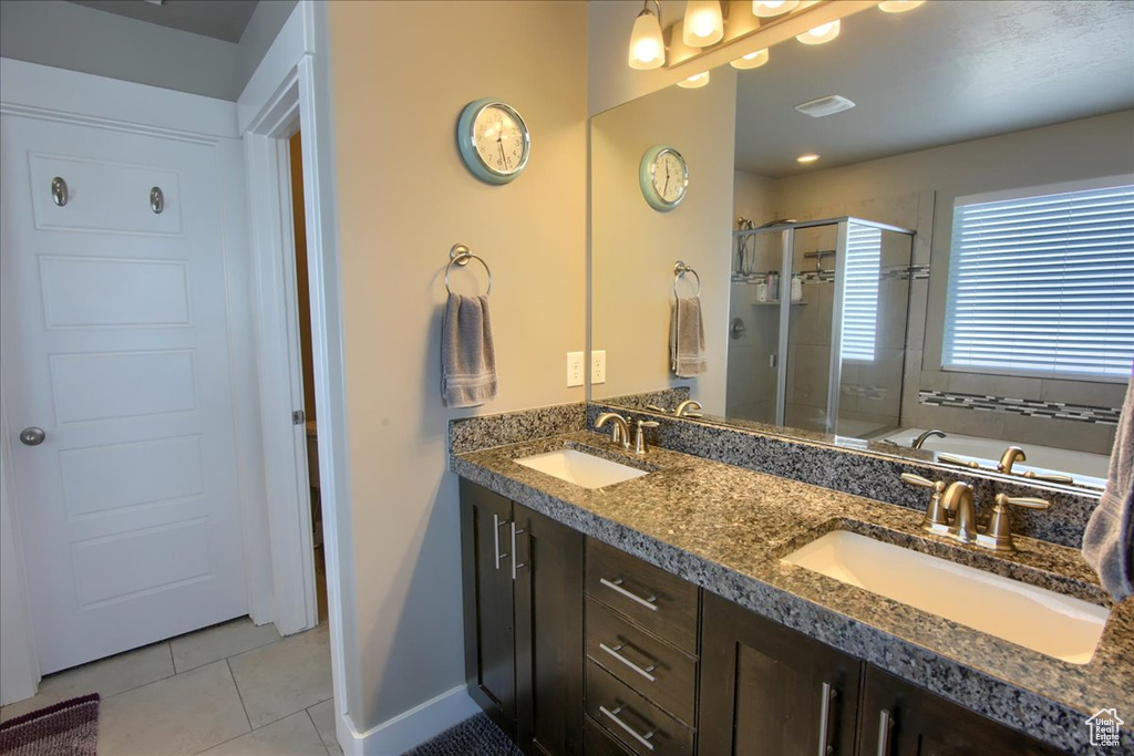 Bathroom with tile patterned floors, a stall shower, a bath, and double vanity