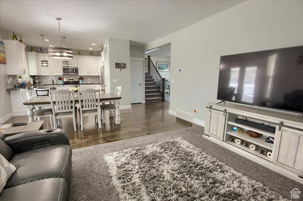 Living area featuring stairway, dark wood finished floors, and recessed lighting