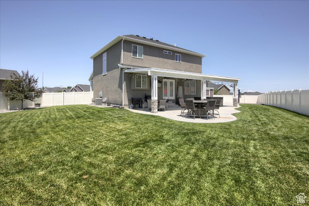 Back of property with stucco siding, a fenced backyard, and a patio
