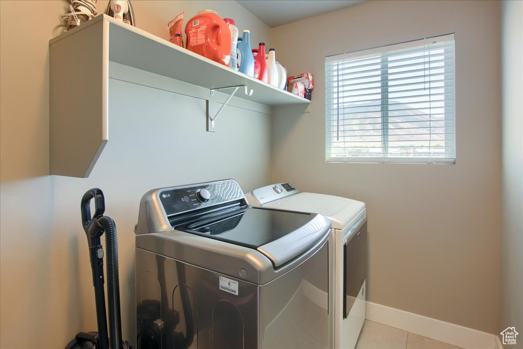 Laundry room with separate washer and dryer and light tile patterned floors