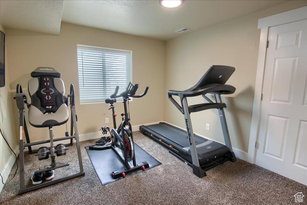 Exercise room featuring carpet and baseboards