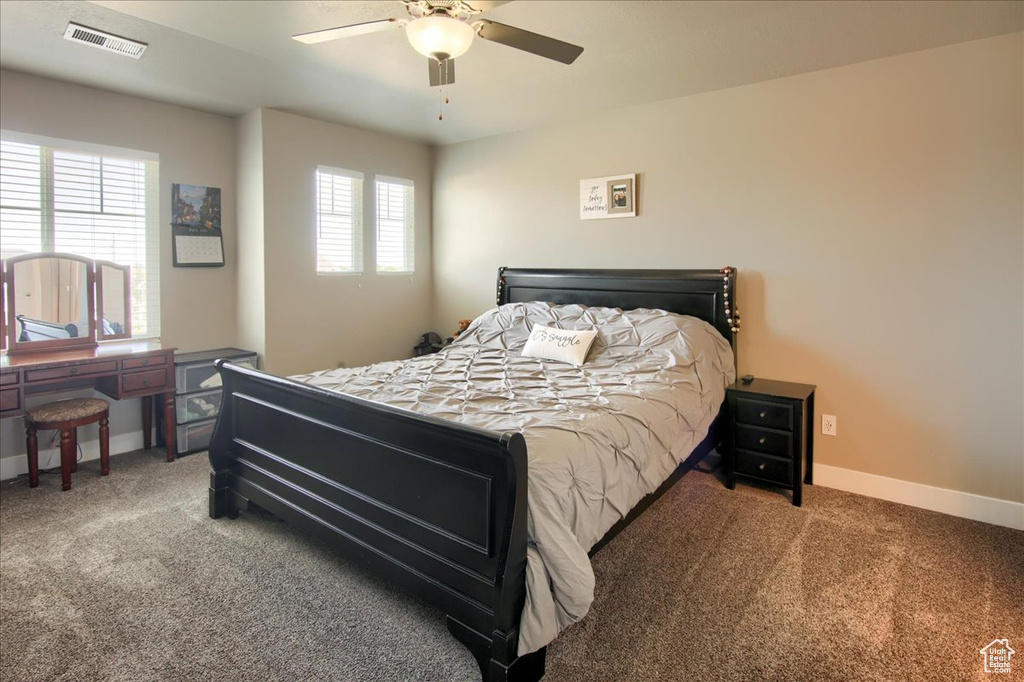 Carpeted bedroom featuring baseboards and a ceiling fan